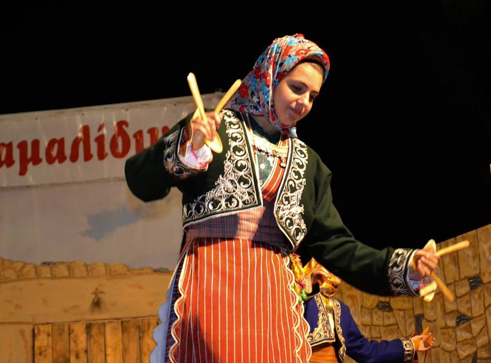 Χορεύτρια του συλλόγου με παραδοσιακή φορεσιά των Φαράσων και ξύλινα κουτάλια